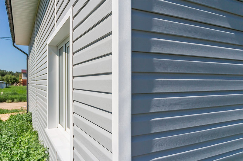 The facade of the house is finished with vinyl siding.